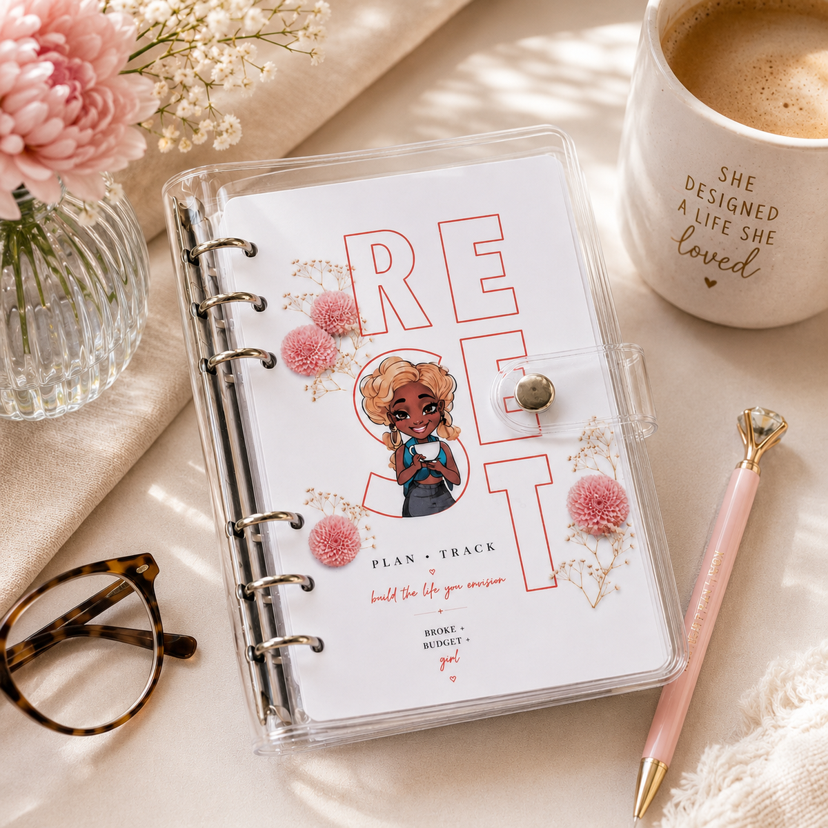 Savannah handmade financial planner in clear binder with pink floral cover, styled with coffee, flowers, and planner accessories