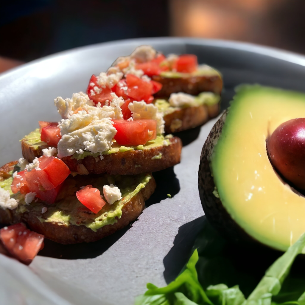 avocado smashed toast with tomatoes and feta cheese on a plate